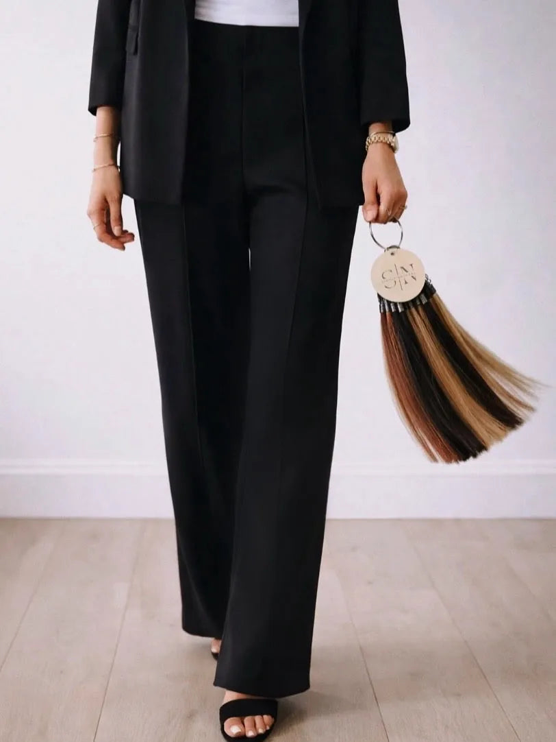 Stylist in black suit holding Simply Natural color ring of hair swatches