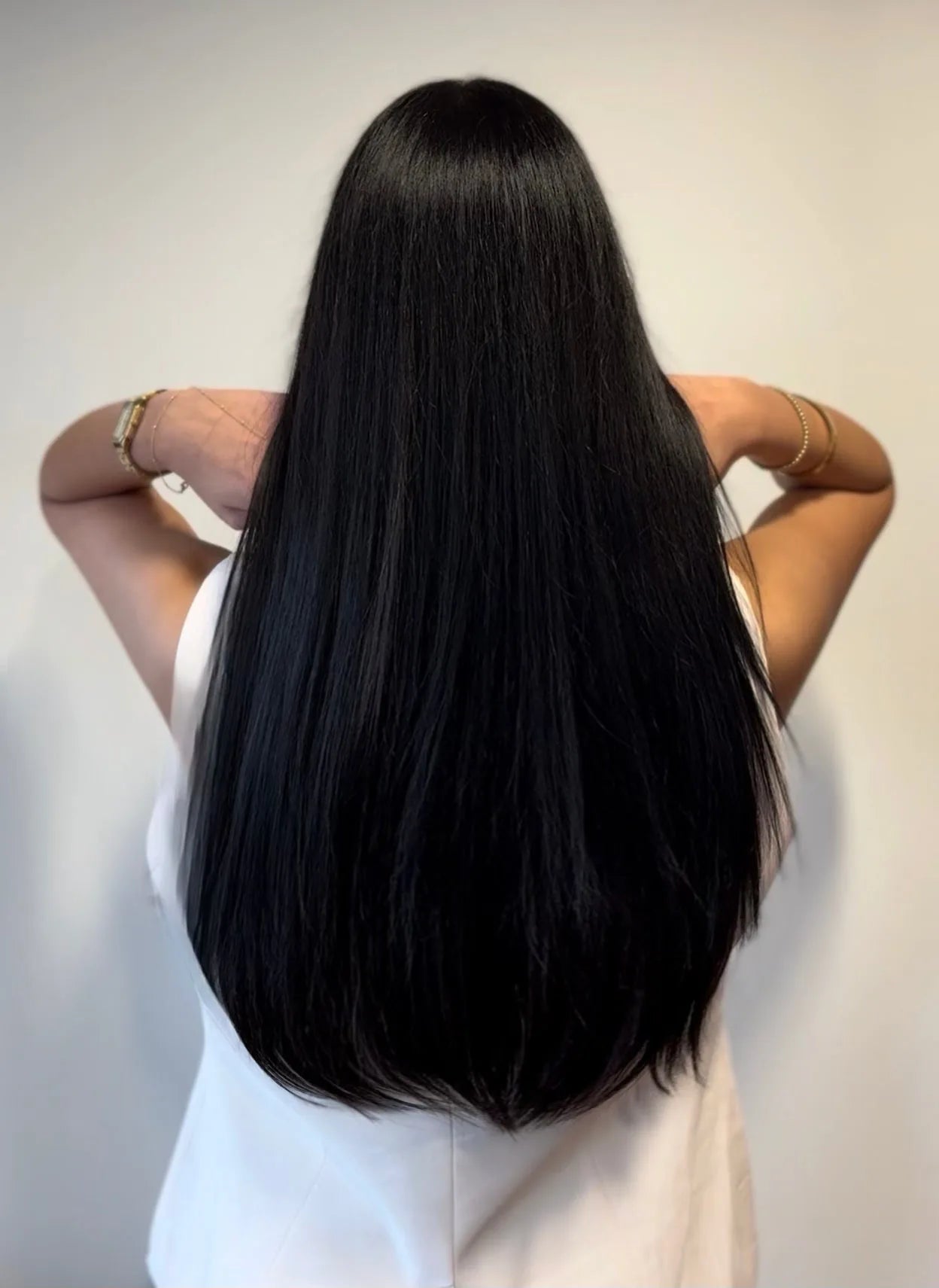 Back view of client with long sleek black Mago Method extensions